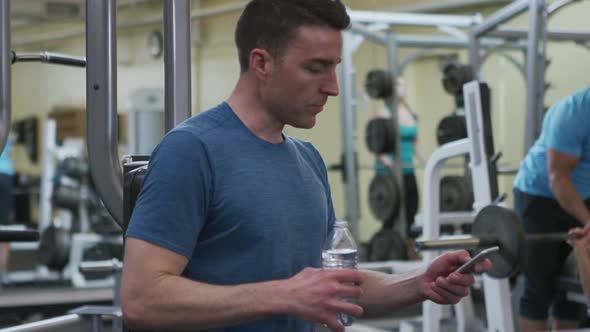 Man at gym drinks water
