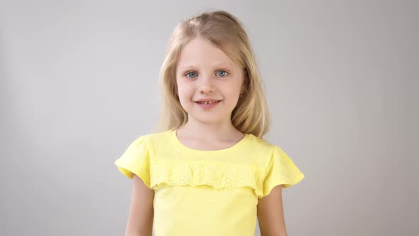 Girl with an Apple. Little Girl Holds an Apple in Her Hand and Looks at the Apple. Girl in a Bright alt