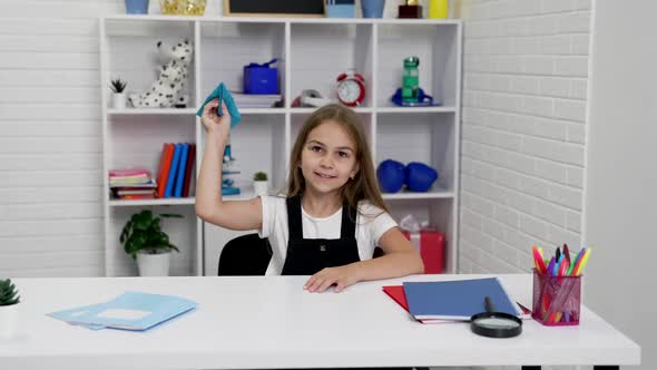 Smiling Teen Girl Having Fun Playing with Paper Plane at School Lesson in Classroom Have Fun alt