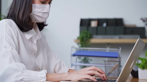 Asian young businesswoman working on a computer in the office with a new normal lifestyle concept alt