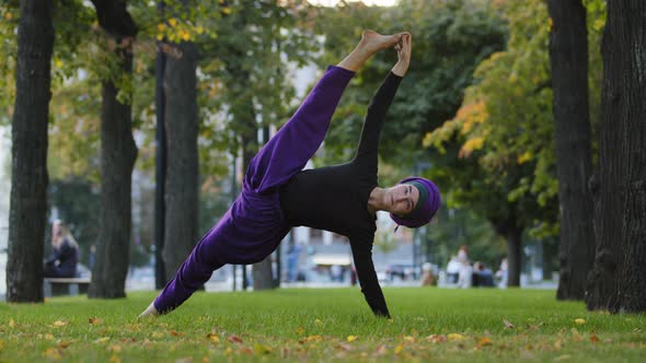 Strong Sportive Islamic Girl in Hijab Yoga Teacher Woman Stands in Side Plank on Grass in Park Doing alt