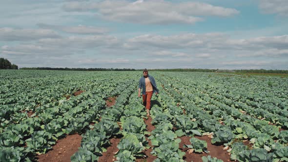 Man Walking Along Farm Field alt