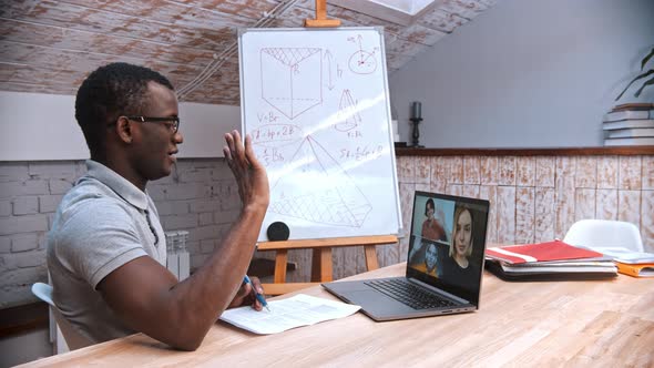 An Online Maths Lesson - an African-american Man Teacher in Glasses Greeting His Students on the alt