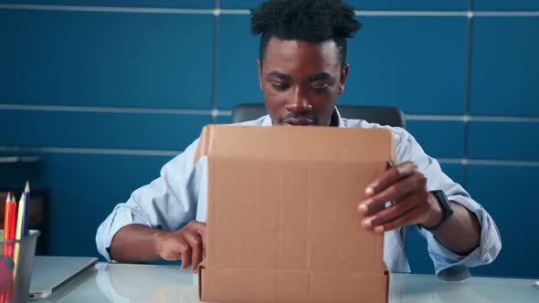 Excited African Man Receives Parcel Open Box at Home Satisfied with Great Goods alt