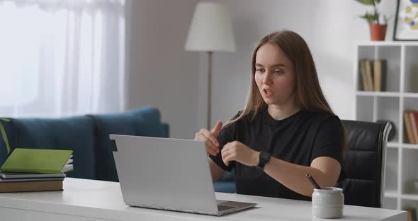 Female Specialist Is Consulting Client By Internet Sitting at Home Sitting in Front of Laptop with alt