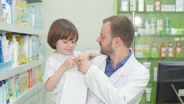 Cheerful Pharmacist Smiling To the Camera with a Cute Little Boy