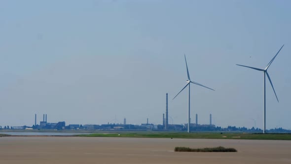 Wind Turbines with Blades for Power Generation Against the Background of an Industrial Enterprise