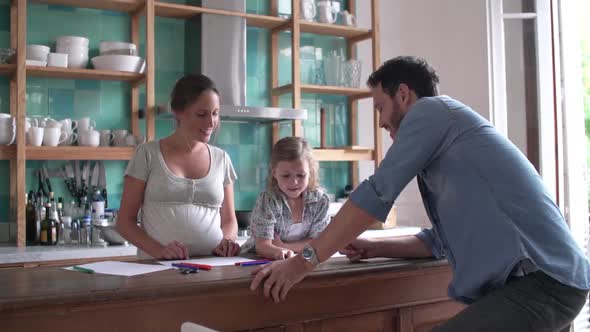 Parents coloring with young daughter in the kitchen alt