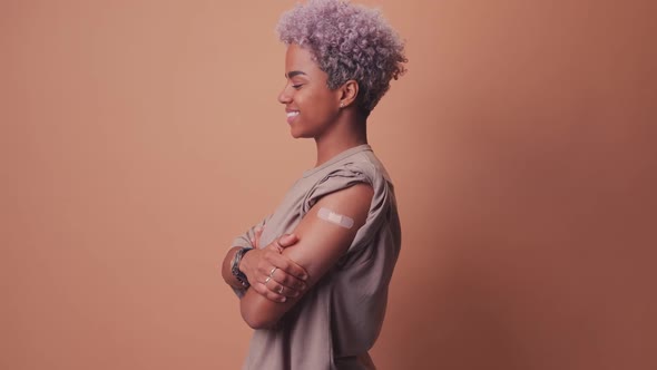 African Woman Showing Arm With Plaster Bandage After Covid19 Vaccine Injection alt