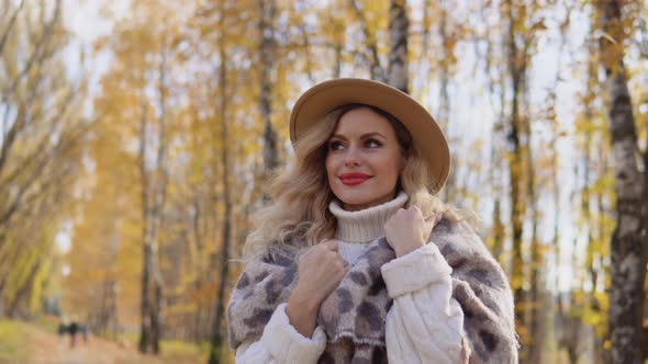 Portrait of a Smiling Happy Cheerful Woman in a Brown Hat in Autumn Park alt