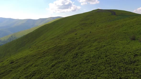 Aerial flight over green hill mountains. FPV Dynamic drone shot alt