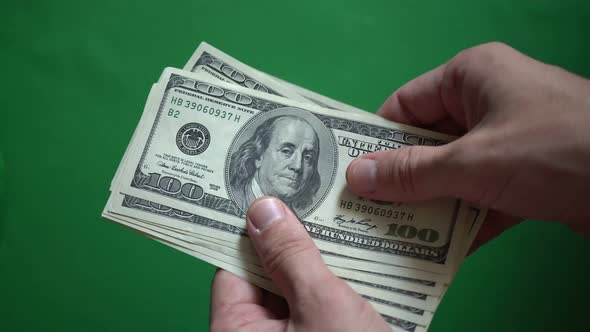 Man Counting 100 Dollars Isolated On Chroma Key Green Screen Background alt