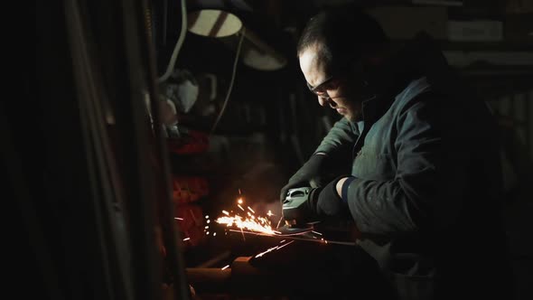 Man Works With Small Electric Grinder. alt