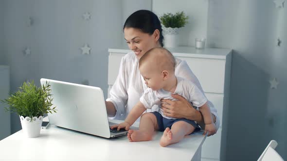 Young Mother Working with Laptop at Home alt