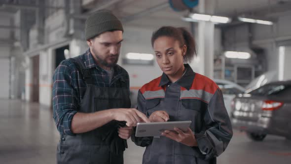 Portrait of Auto Mechanics with Tablet Discussing Work alt