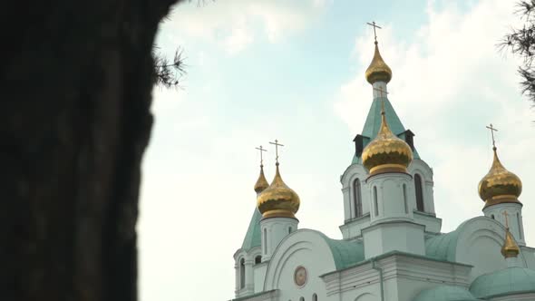 Christian cathedral with golden domes and crosses against skies. alt