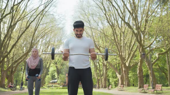 Muslim Couple Using Sport Equipments for Training at Park alt