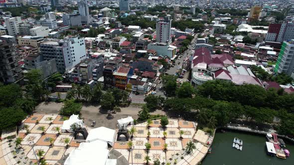 drone flying over a busy street in Makassar city Sulawesi Indonesia on a sunny day with large buildi alt