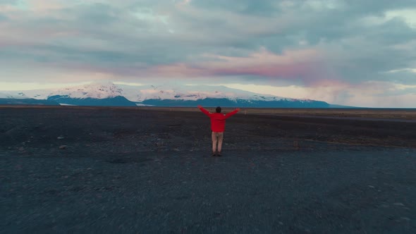 Man on rocky ground in mountains jumping alt