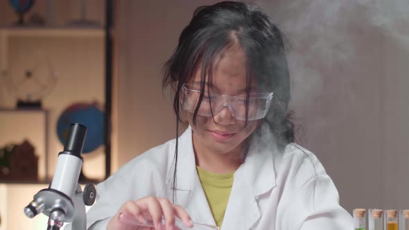 Asian Scientist Girl With Dirty Face Mixing Chemical Liquids In Flasks. Child Learn With Interest alt