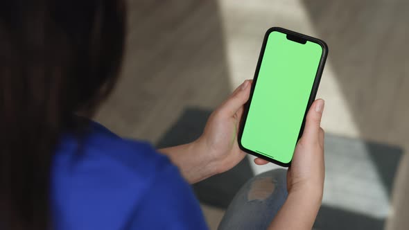 Girl Holding Chroma Key Green Screen Mock Up Smartphone Watching Content Without Touching or Swiping