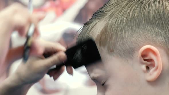  Barber's Hands Combs and Cut Bangs on Blond Short Boy's Hair with Scissors