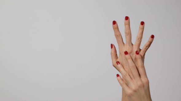 Beautiful Woman's Hands with Bright Red Manicure