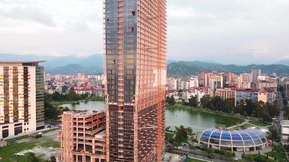 Aerial drone view of a building under construction in Batumi, Georgia. Modern buildings nearby, city alt