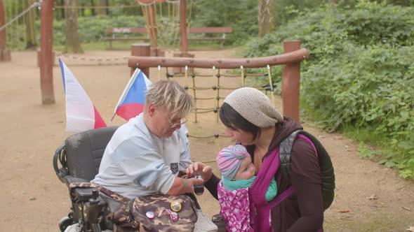 fun meeting friends friend She sitting wheelchair Use baby carrier Shake hands