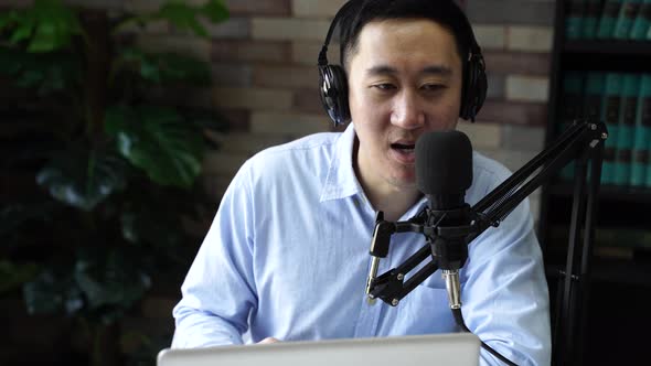 Young Adult Businessman Recording Podcast Talk Show at Home Studio with Computer Laptop on Table alt
