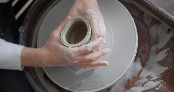 Top View Ceramist Sculpts a Jug on a Potter's Wheel Video From Pottery Workshop Potter Makes alt