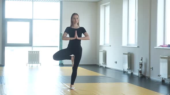 Yoga girl student in Studio. a woman meditates in a balance pose in yoga Studio alt