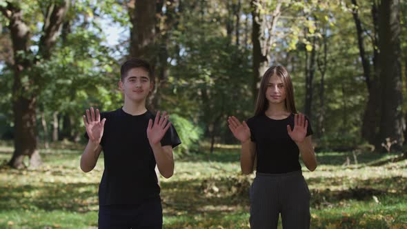 MS Boy and Girl Jumping and Throwing Dry Leaves in Park alt
