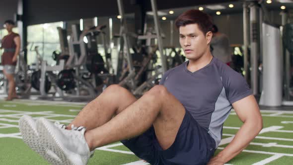 Handsome young athlete Asian guy exercise doing push-ups fat burning workout in fitness class.