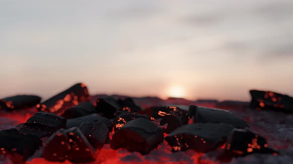 Glowing Embers And Charcoals In Front Of Sunset