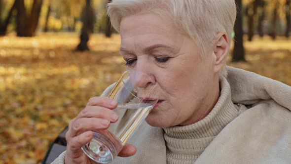 Closeup Happy Elderly Woman Drinking Glass of Fresh Pure Filtered Water Maintains Balance Smiling alt