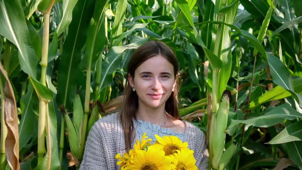 Woman with Sunflowers Boquet Posing and Smiling Between Tall Corn Plants Field