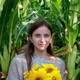 Woman with Sunflowers Boquet Posing and Smiling Between Tall Corn Plants Field - VideoHive Item for Sale