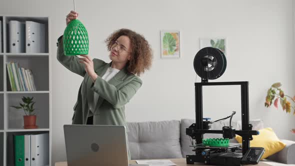 Portrait of Young Woman Using 3D Printed Lamp Shade Model Printed on 3D Printer for Home Improvement alt