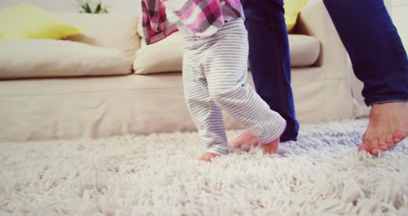 Dad assisting baby to walk alt