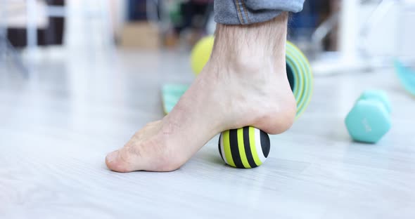 Person Does Massage and Exercises for Legs with Ball alt