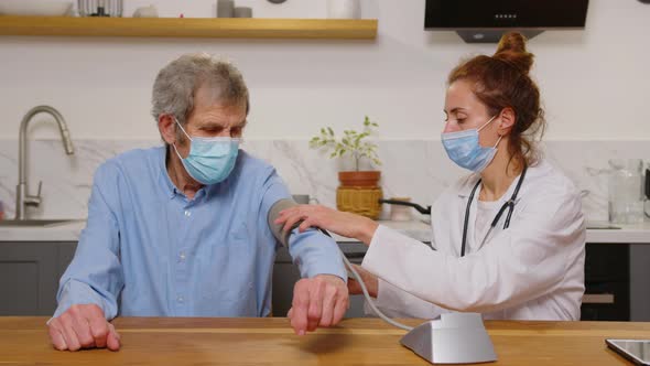 Therapist Wear White Coat Face Mask Due Corona Virus Pandemic Outbreak Talk to Elderly Patient alt