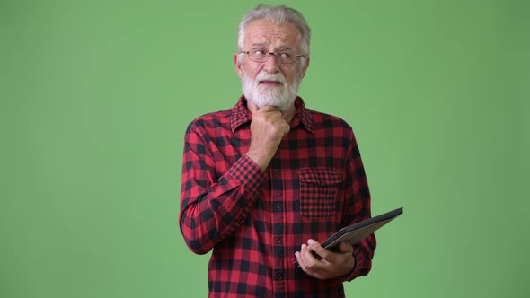 Handsome Senior Bearded Man Against Green Background alt