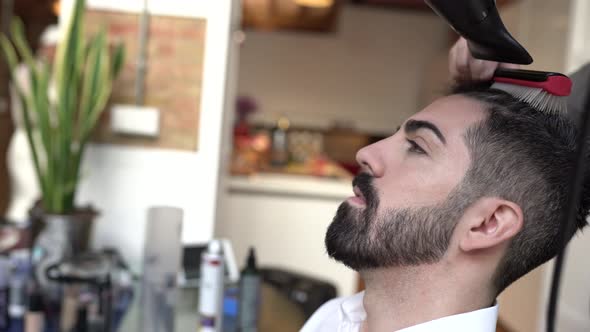 Hairdresser styling hair of groom for wedding alt