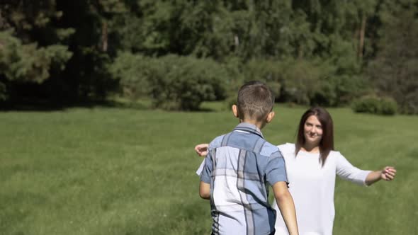 The Little Son Runs Quickly to His Mother and Hugs Her alt