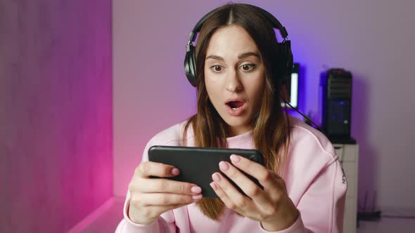 Lifestyle Young Woman in Headphones Play Game and is Perplexed alt