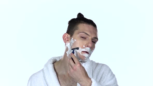 Man Shaves Stubble with Razor Blade. White Background. Slow Motion alt