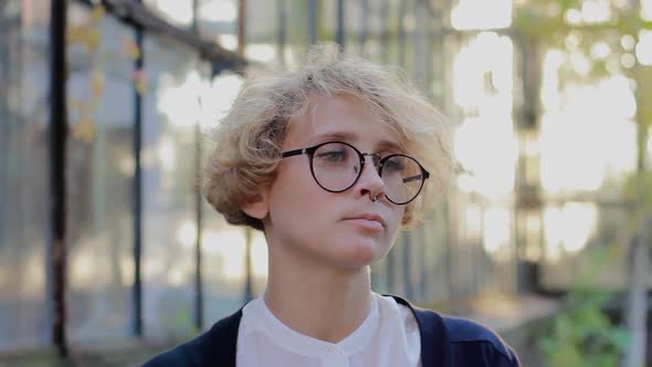 Offended Blonde Woman with Glasses Sadly Looks at the Camera