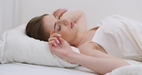 Young Female Sleeping in Bed, Waking Up in the Morning, Close-up of a Female Face, Woman Opens Her alt