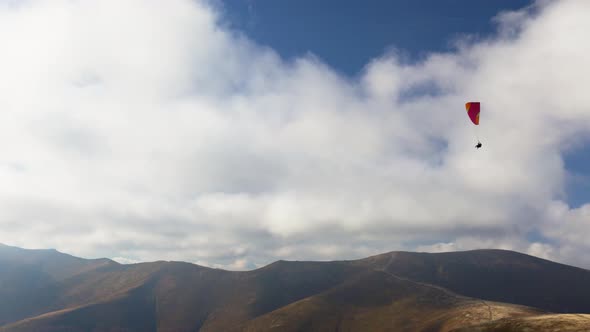Paragliding in Highland Against Giant Forestry Mountains alt